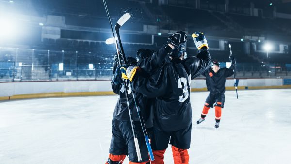 ice hockey rink arena forward player hit puck scored goal professional hockey team celebrates victory embrace each other tension emotional sport moment