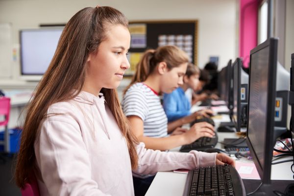 line high school students working screens computer class