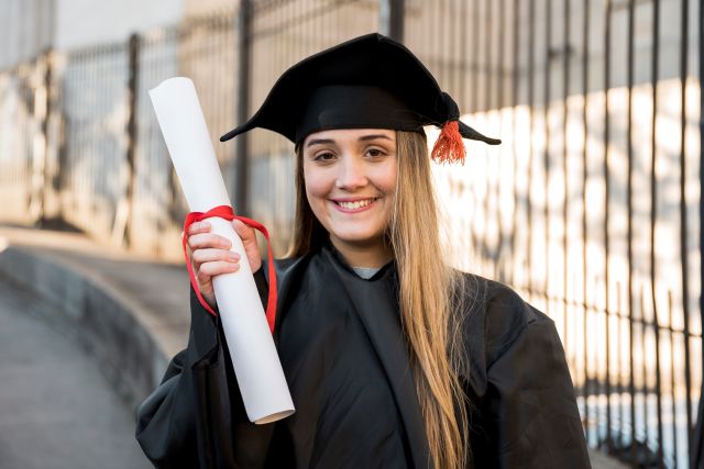 college graduate holding her certificate